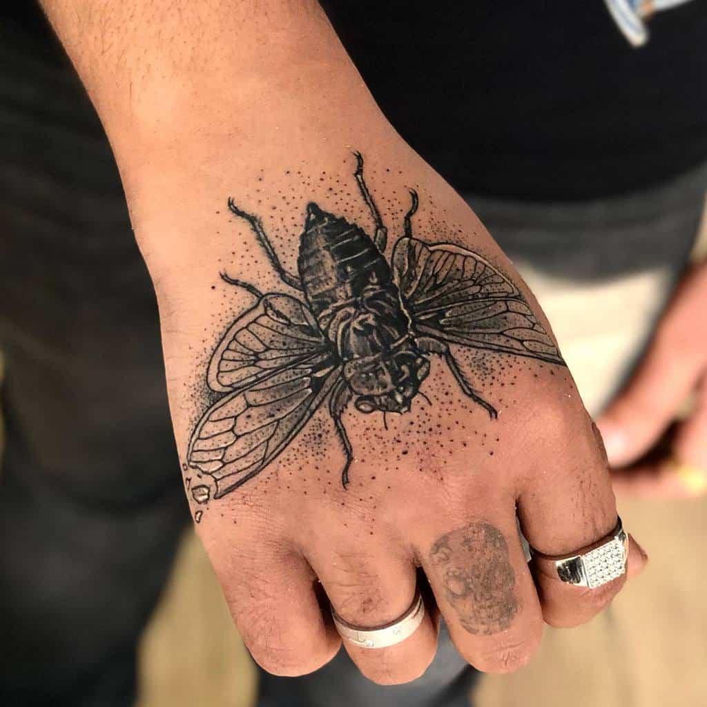 Hand with a detailed cicada tattoo