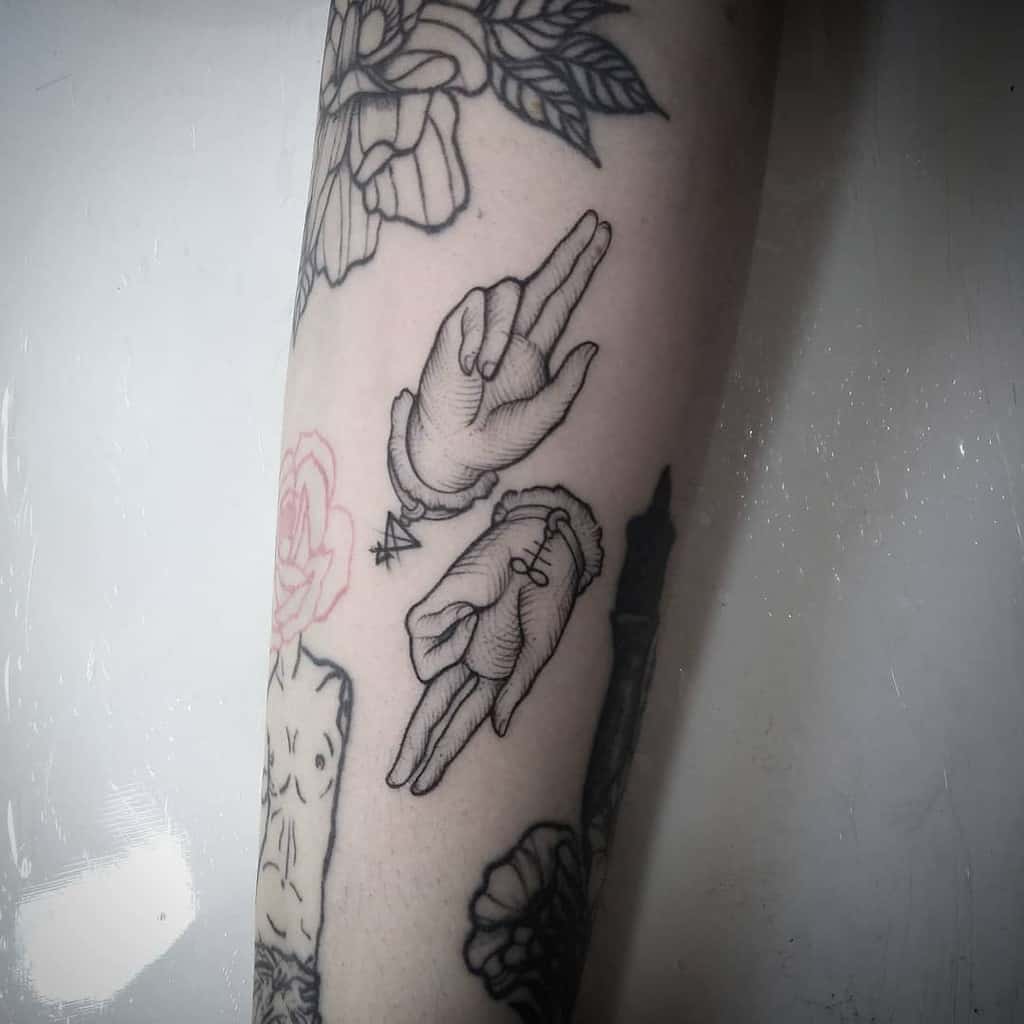 Minimalistic forearm tattoo of hands symbolizing 'as above, so below,' with geometric details and fine line artistry