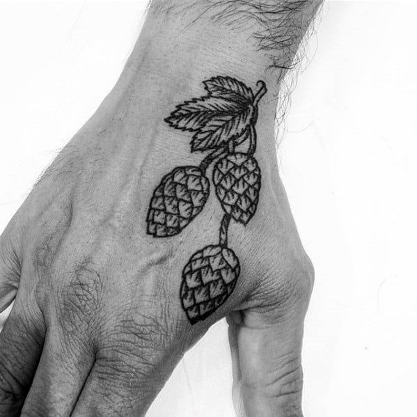 Black linework tattoo of a hop vine on the hand, featuring three detailed hop cones and a pair of leaves for a clean, botanical design.