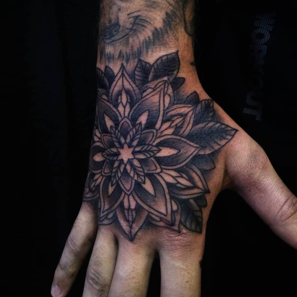 Hand tattoo featuring an intricate floral design with detailed petals and leaves