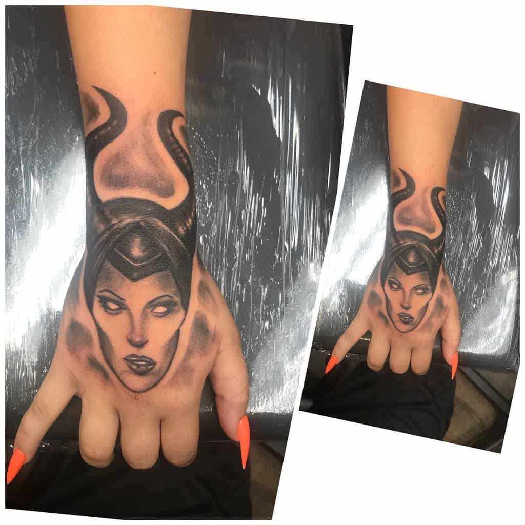 Striking hand tattoo of Maleficent with bold black horns and intense shading, creating a powerful and dramatic design