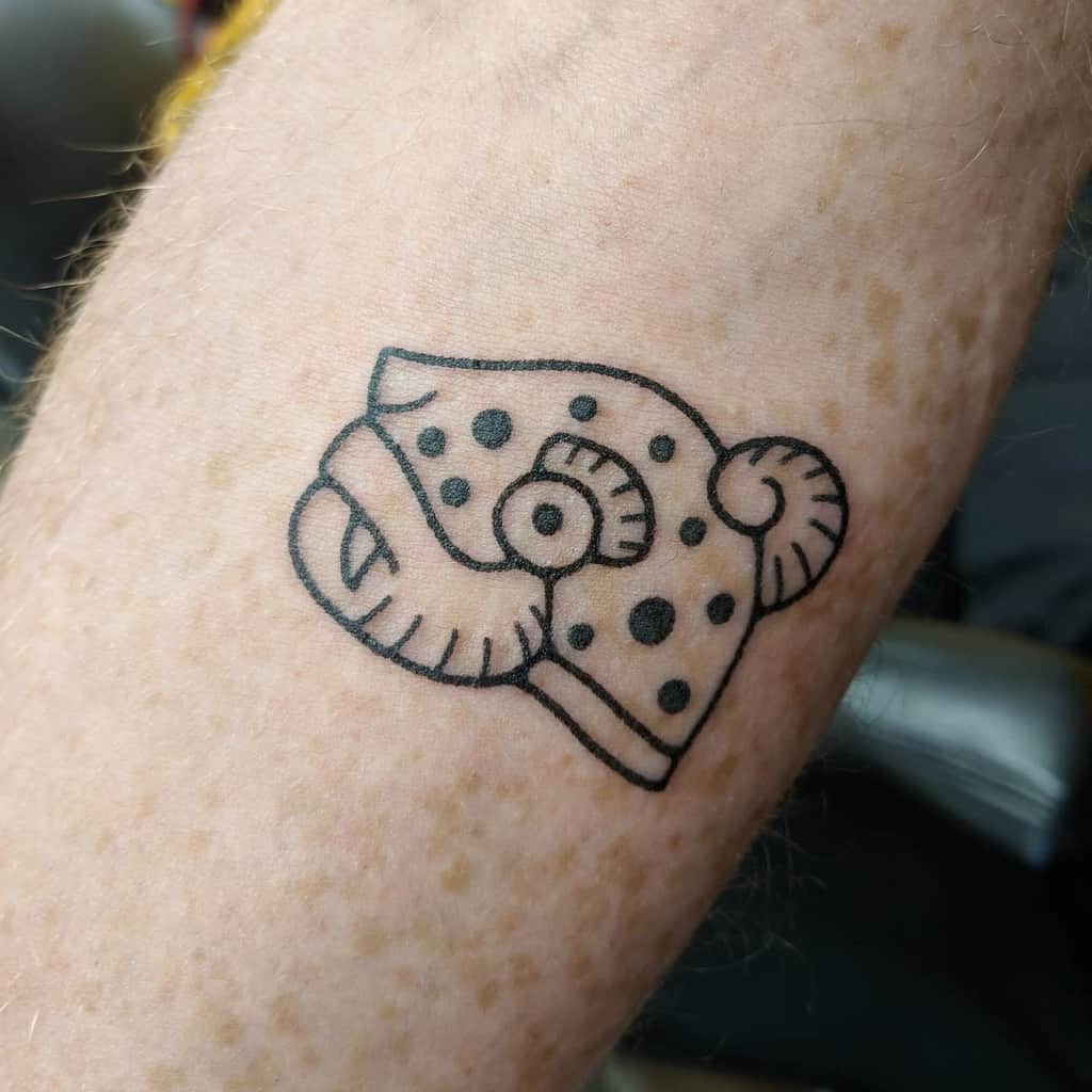 A minimalist black line tattoo of a fish with a unique circular and dotted design, located on the forearm.