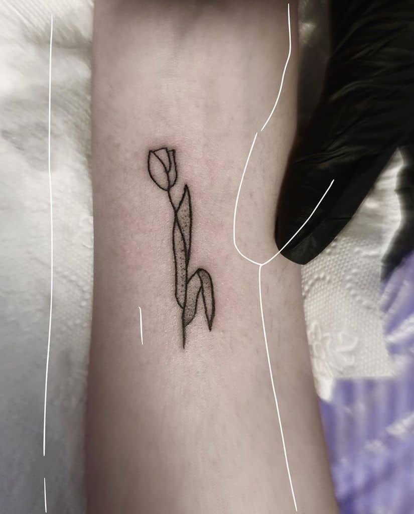 A simple black-line tulip tattoo on the forearm, with clean geometric lines forming a minimalistic flower and stem.