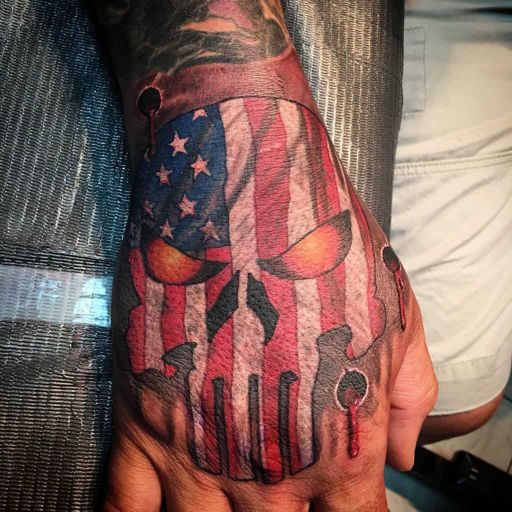 Patriotic Punisher Skull tattoo on the hand, featuring an American flag overlay and fiery eyes, combining national pride with a fierce, bold design