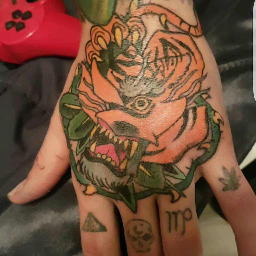 A colorful dragon tattoo covers the back of a hand, intertwining with the fierce stripes of a tiger, while various small symbols adorn the fingers