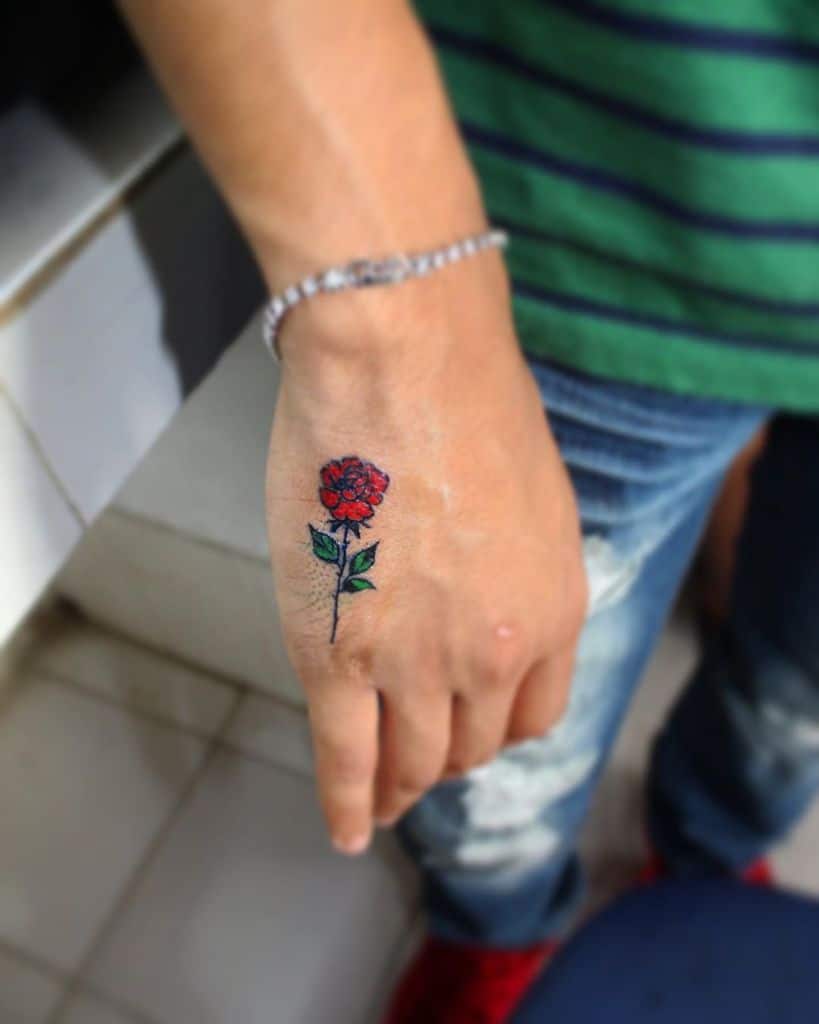 A hand with a red rose tattoo