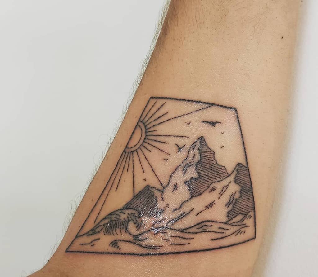 Minimalist mountain and ocean tattoo, featuring a rising sun, birds, and waves within a geometric frame
