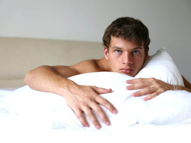 handsome man laying on bed