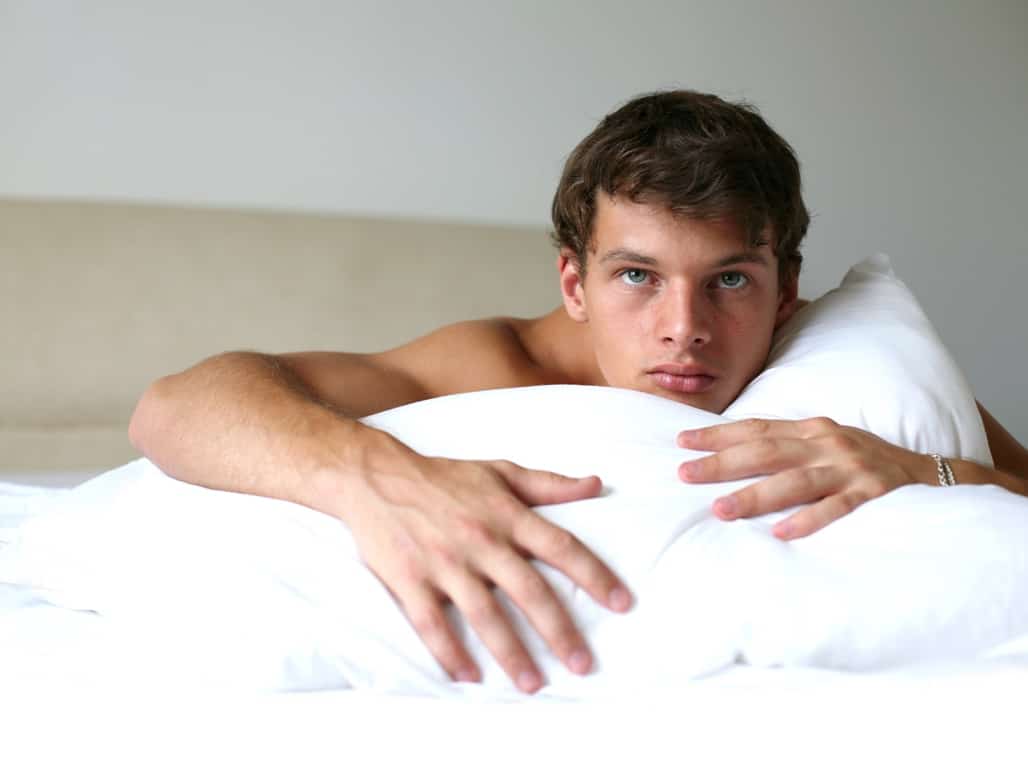 handsome man laying on bed