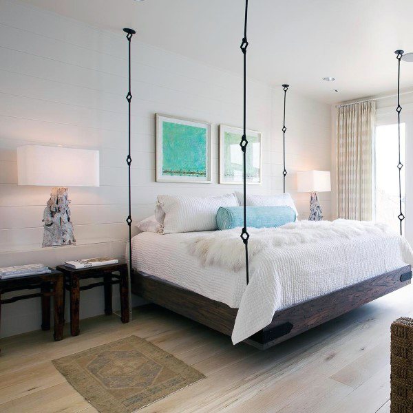 Bright bedroom with a hanging bed, white bedding, and modern decor featuring green accents.