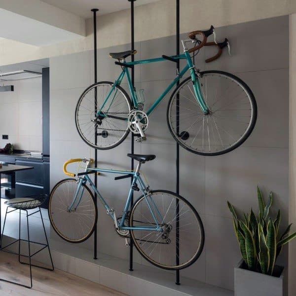 Two vintage bikes mounted on a sleek vertical pole rack in a modern living space.