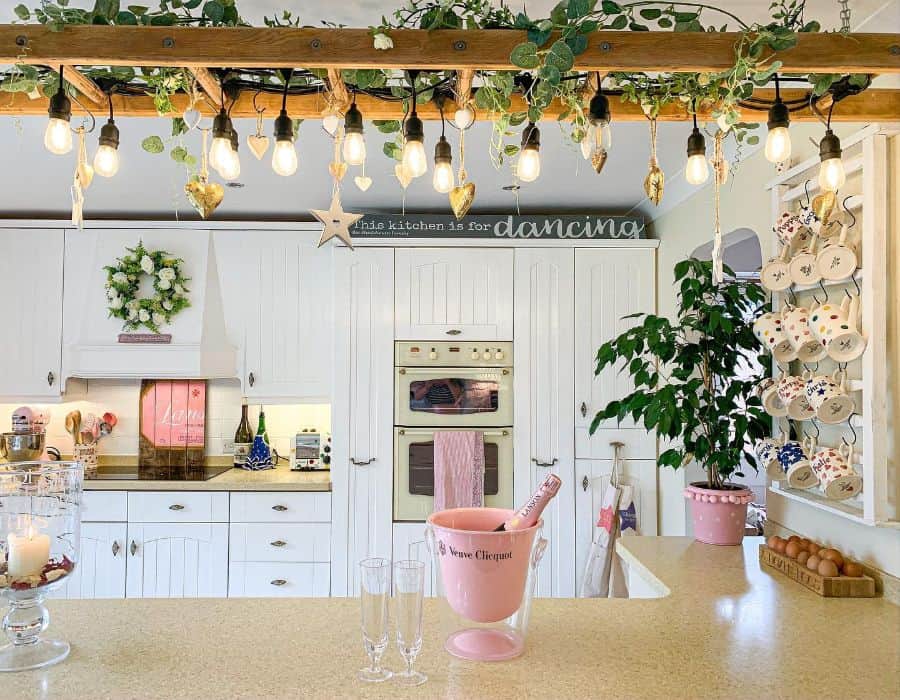 hanging bulbs from ladder in white country kitchen hanging mugs