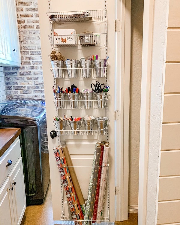 Over-the-door organizer with art supplies and wrapping paper in a laundry room