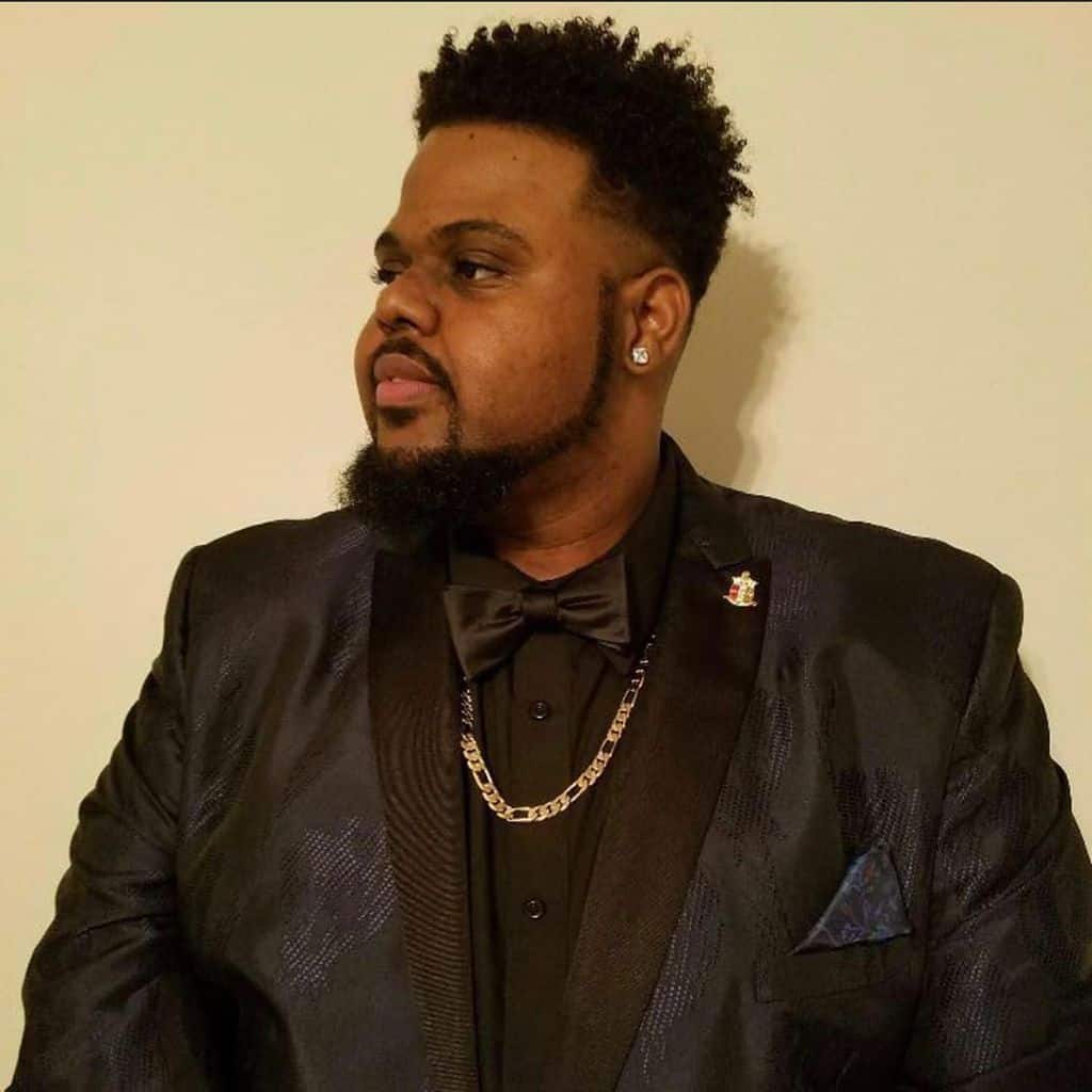 A curly hairstyle with a sharp distinction between the hair on top and the bottom, created by the hard part