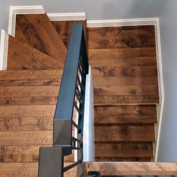 U-shaped wooden staircase with metal railing in a modern home design.