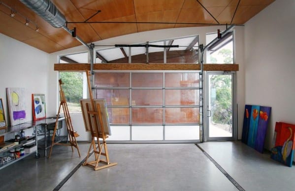 Art studio garage with wooden ceiling panels, glass garage door, and modern concrete flooring.