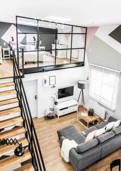 Modern loft with pastel accent walls, glass railing bedroom, and cozy living area with hardwood floors.