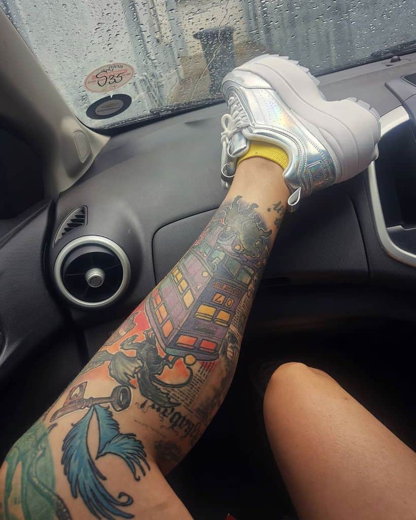 Vibrant Harry Potter-themed tattoo featuring the Knight Bus, a flying key, the Daily Prophet, and magical elements in bold colors