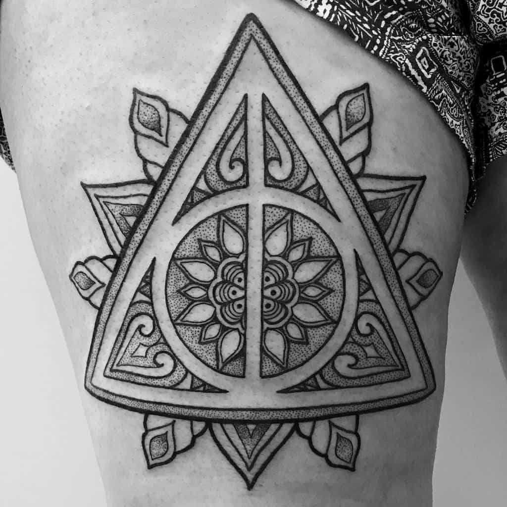 An intricate Deathly Hallows tattoo with mandala and geometric patterns