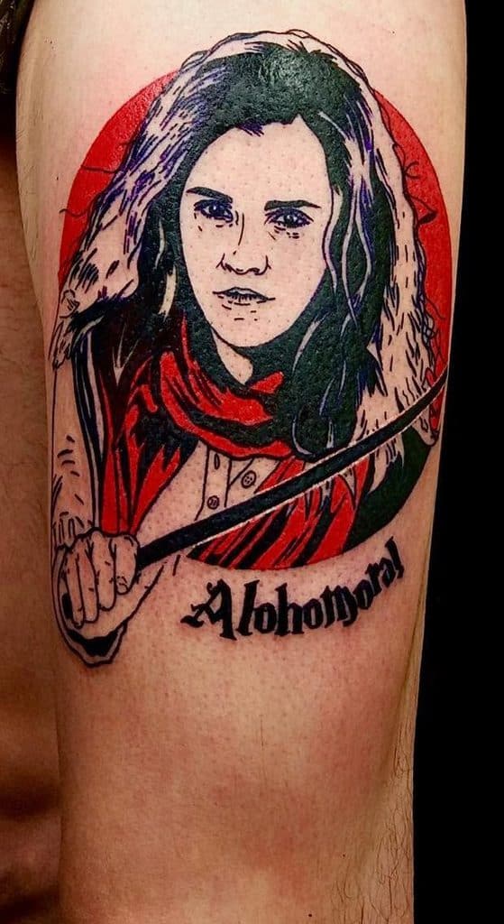 Bold Hermione Granger tattoo from Harry Potter, featuring her casting a spell with 'Alohomora' written below, set against a red backdrop