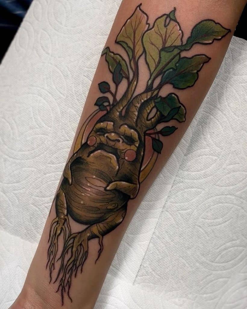 Detailed Mandrake tattoo from Harry Potter, featuring a chubby root-like creature with green leaves, a sleepy expression, and earthy tones