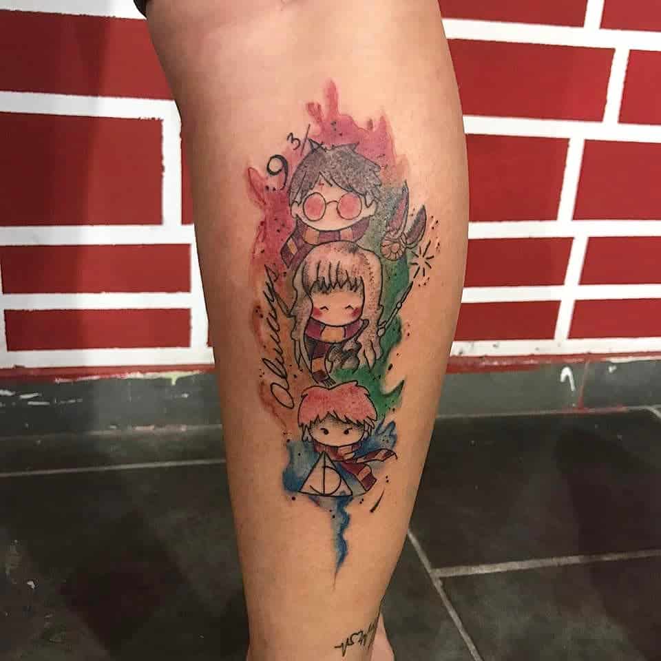 Chibi-style Harry Potter tattoo featuring Harry, Hermione, and Ron with watercolor splashes, Gryffindor scarves, and magical elements