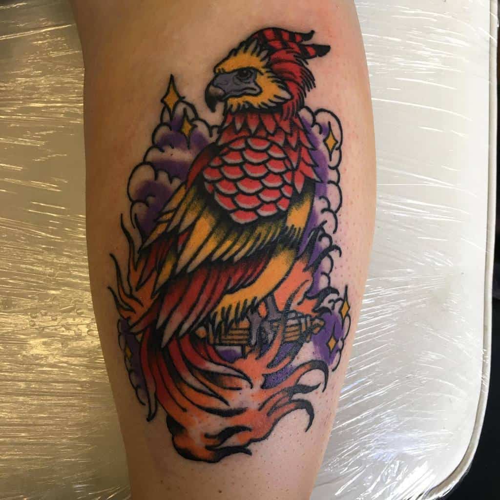 Bold and colorful Fawkes the phoenix tattoo from Harry Potter, featuring vibrant red, orange, and yellow feathers rising from flames