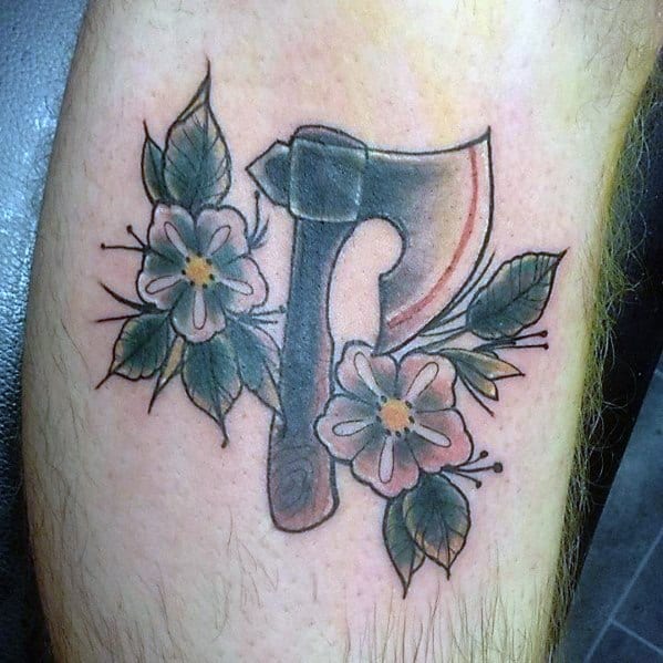 Hatchet tattoo with a shaded blade and wooden handle, surrounded by delicate flowers and leaves, blending rugged and soft elements in a balanced design.