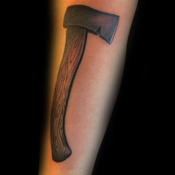 Realistic hatchet tattoo on the forearm with a wood-textured handle and a shaded black blade, designed with smooth gradients for depth.