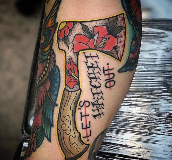 Colorful hatchet tattoo with floral patterns on the blade, a wood-textured handle, and the phrase "LET'S HATCHET OUT" inked in bold lettering.
