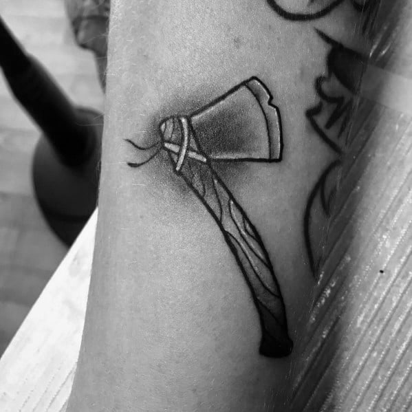 Minimalist black and grey hatchet tattoo with a wrapped handle and subtle shading, creating a clean and simple design on the forearm.