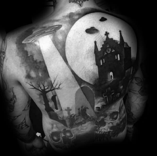 Full back tattoo featuring a UFO beaming down light over a haunted graveyard and church scene, symbolizing mystery, fear, and the unknown.