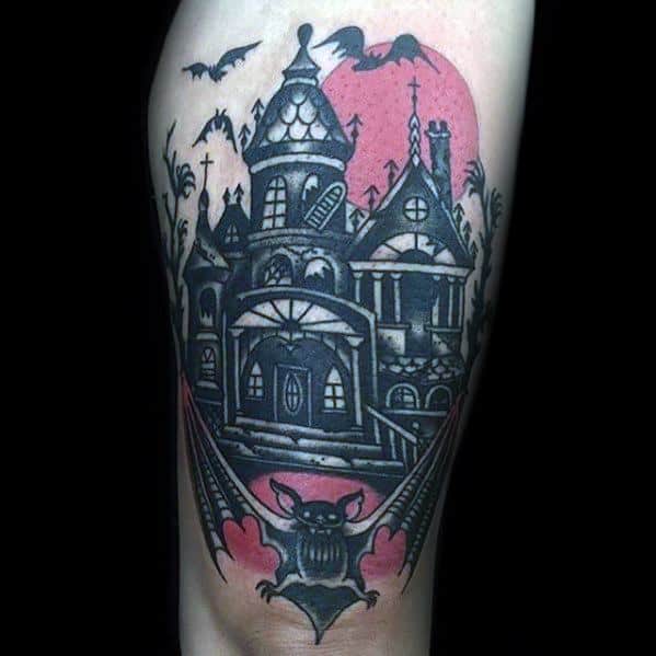 Bold haunted mansion tattoo with a red moon, flying bats, gothic architecture, and a large bat with outstretched wings at the bottom.