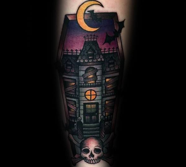 Coffin-shaped haunted house tattoo with glowing windows, crescent moon, flying bats, and a skull with horns at the base.