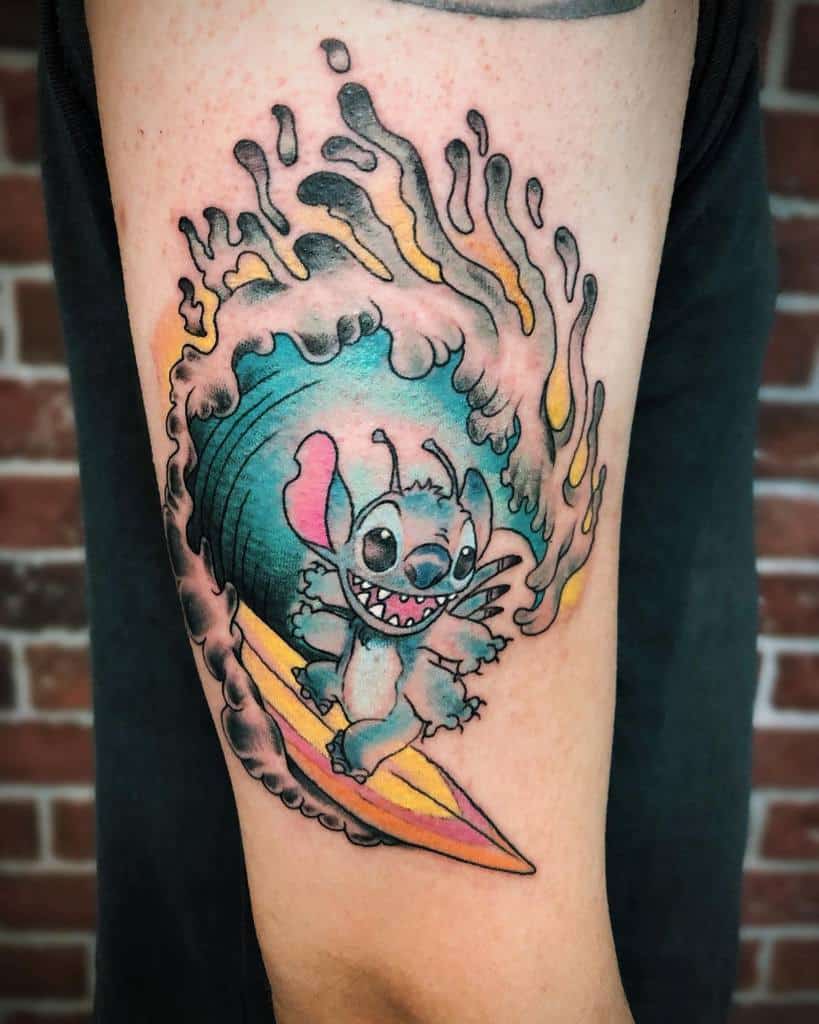 Colorful tattoo of Stitch from Lilo & Stitch surfing on a yellow board, riding a large wave, with vibrant water splashes, on the upper arm.
