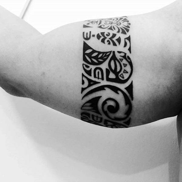 Black geometric tribal tattoo on a man's bicep