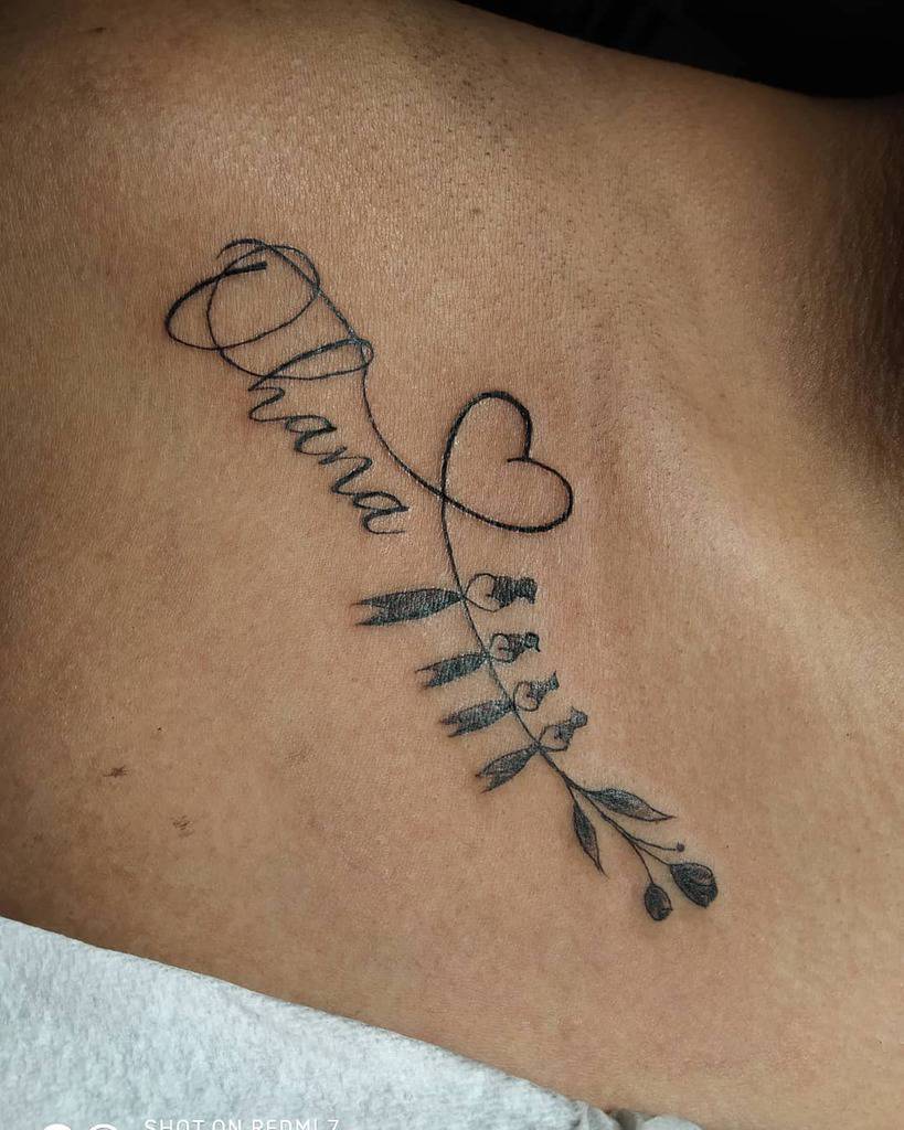 Elegant tattoo with the word 'Ohana' intertwined with a heart and delicate leaves, symbolizing love, family, and growth.