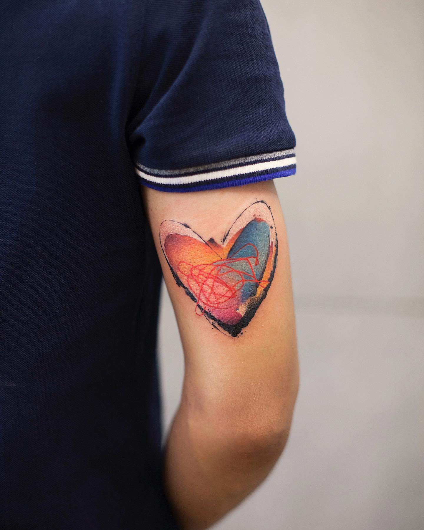 Tattoo of a colorful heart such as blue, pink and orange with abstract patterns