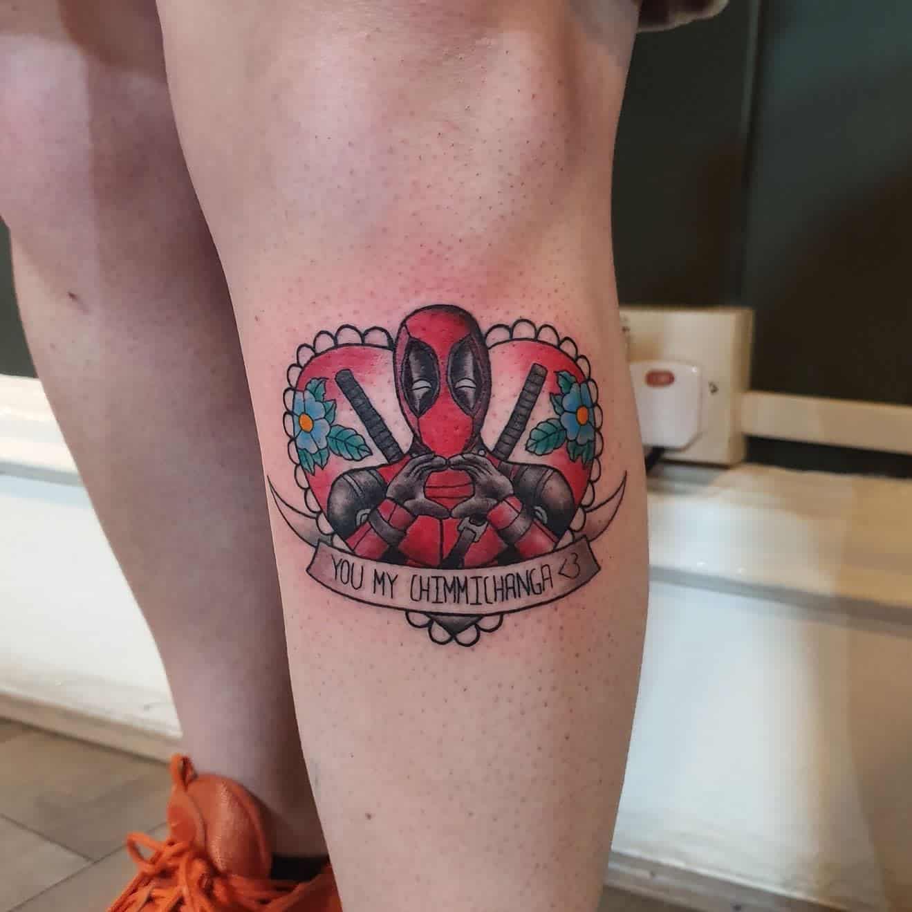 Adorable Deadpool tattoo with a heart background, floral details, and a banner reading "You my chimichanga <3"