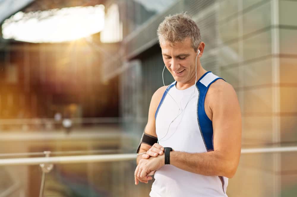 man looking heart rate monitor on his wrist watch