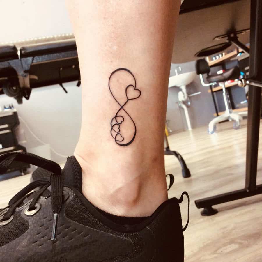 A delicate infinity tattoo with a heart motif, featuring three connected hearts within the loop, symbolizing eternal love.
