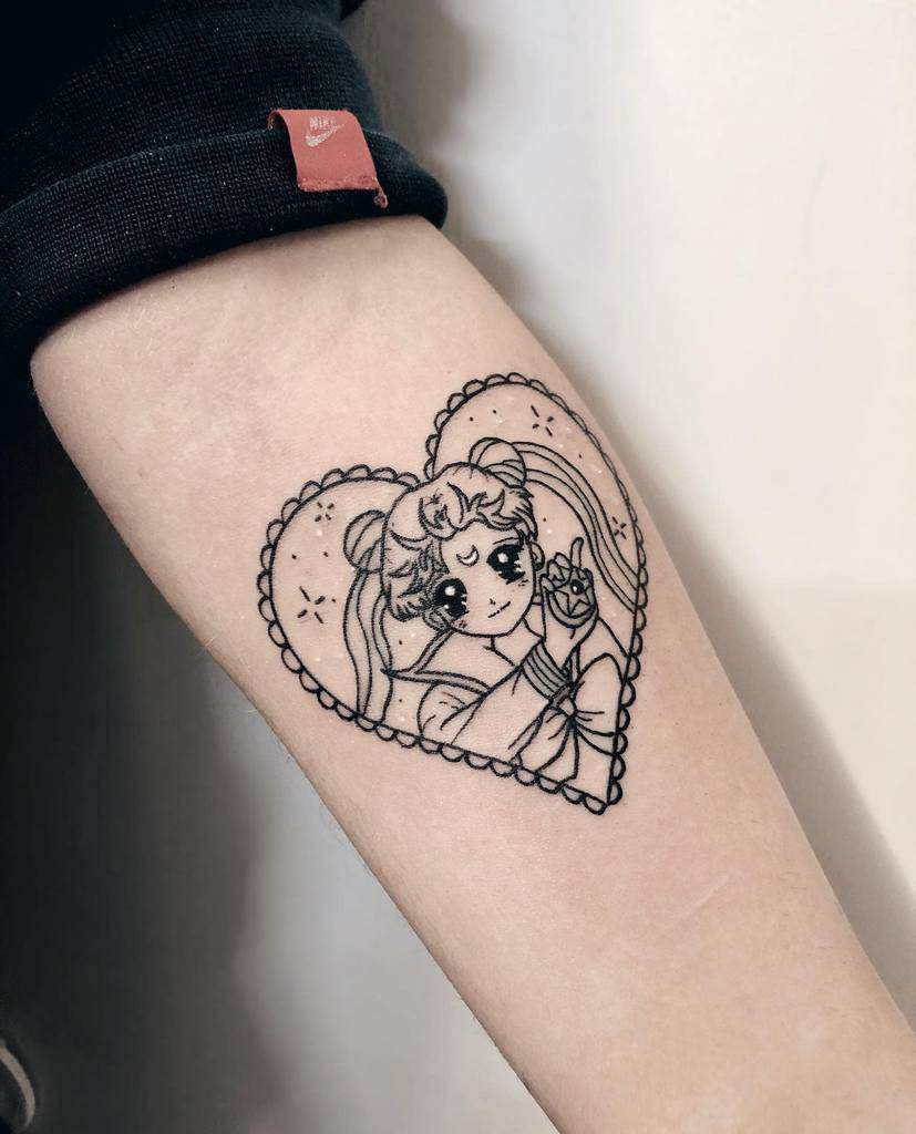Black ink tattoo of Sailor Moon with long flowing hair, framed inside a lace-bordered heart, making a peace sign with sparkles around her