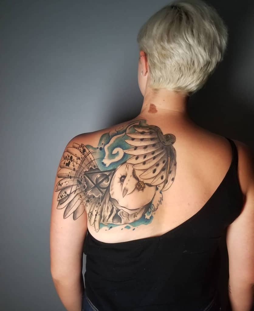 Large, detailed Harry Potter tattoo of Hedwig with outstretched wings, a Deathly Hallows symbol, and blue magical swirls
