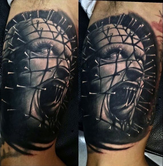 Black and grey *Hellraiser* tattoo of Pinhead screaming, featuring deep shading, intricate pin details, and a hauntingly intense expression.