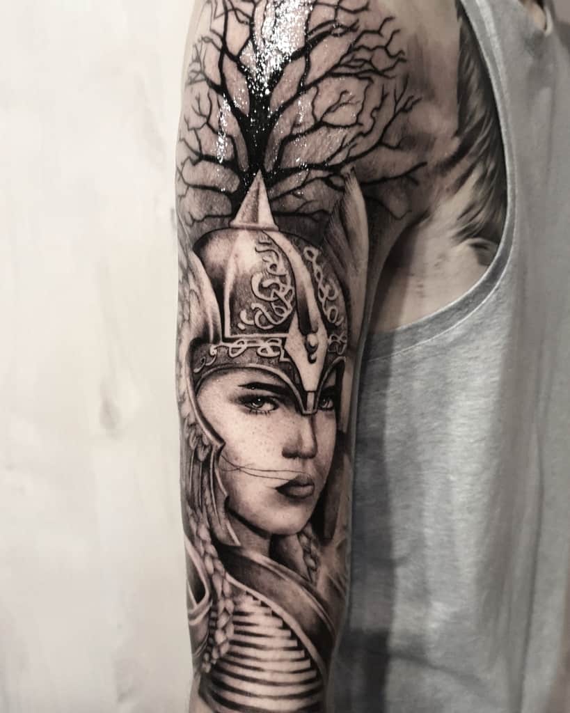 This tattoo combines a fierce Valkyrie warrior with a tree of life, symbolizing strength, wisdom, and connection to Norse mythology.