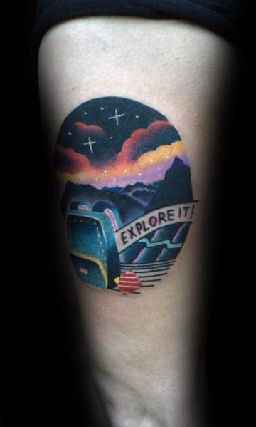 A colorful tattoo of a backpack, mountains, and a road with a sign that says "Explore It!" under a starry sky, symbolizing adventure.