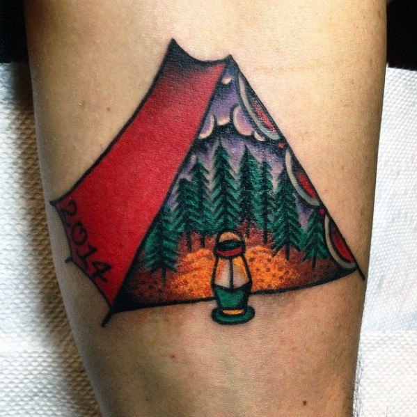 A colorful tattoo of an open tent showing a forest under a starry sky, with a lantern at the entrance and "2014" on the flap.