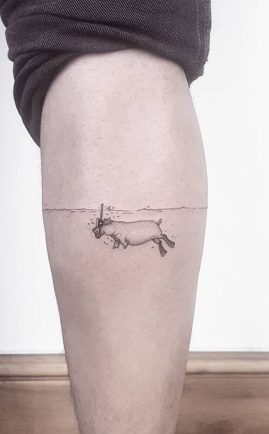 A minimalist black ink tattoo of a cow seemingly cut in half by a thin horizontal line, creating an illusion of sinking into the skin.