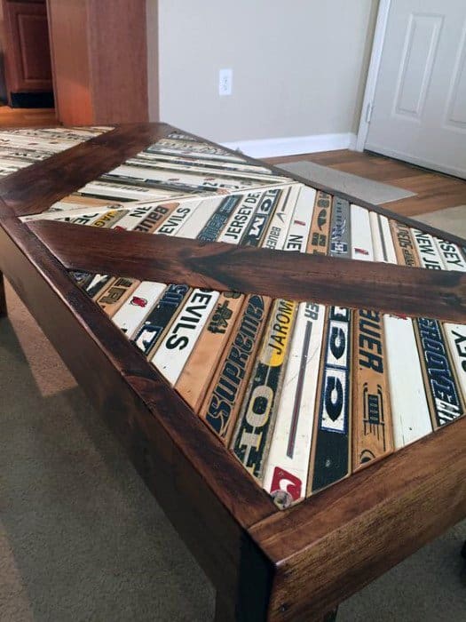 Table with a wooden frame featuring a tabletop made from colorful, overlapping hockey sticks