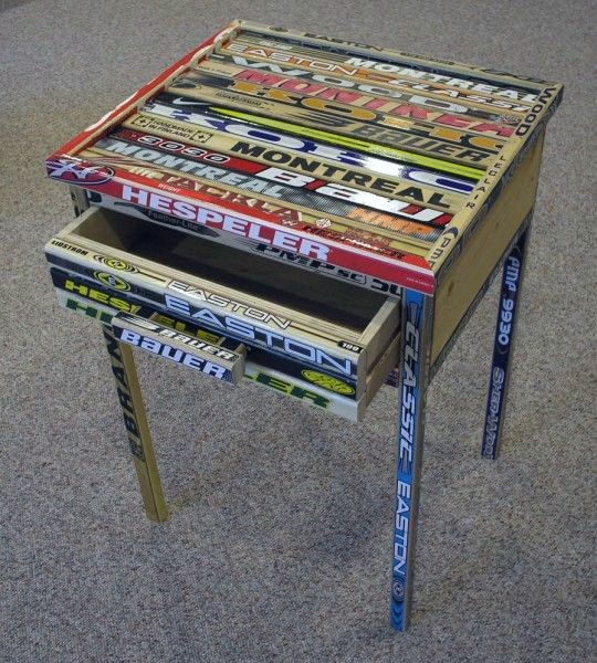 A small table made from repurposed hockey sticks on a carpeted floor